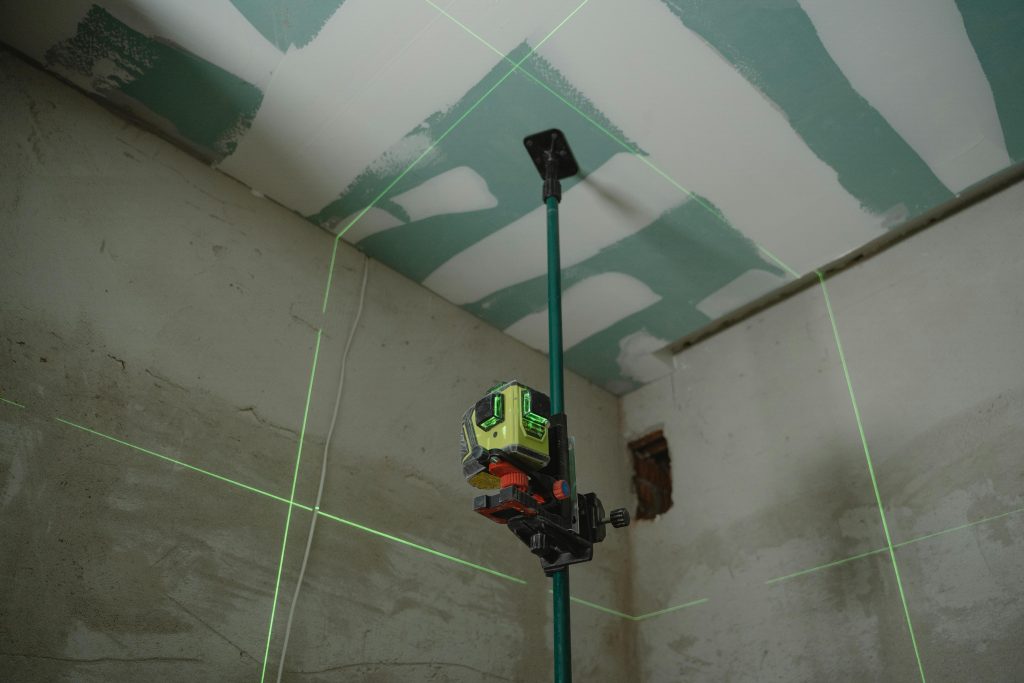 pexels-photo-6473973-6473973 A laser level tool in action at an indoor construction site with marked walls.
