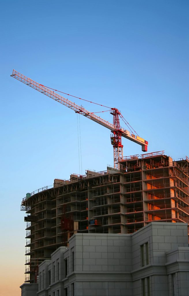 pexels-photo-93400-93400 Tower crane on a high-rise building under construction at sunset, showcasing modern urban development.